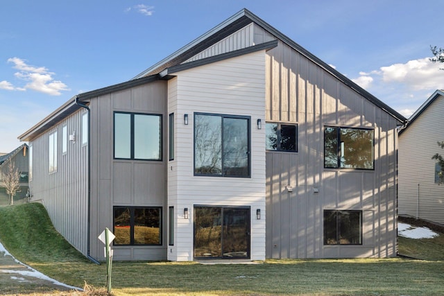 back of house featuring a lawn and board and batten siding