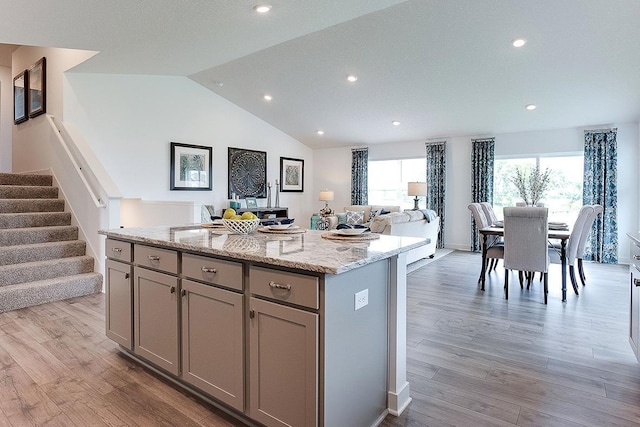 kitchen featuring light wood-type flooring, vaulted ceiling, a kitchen island, and gray cabinetry