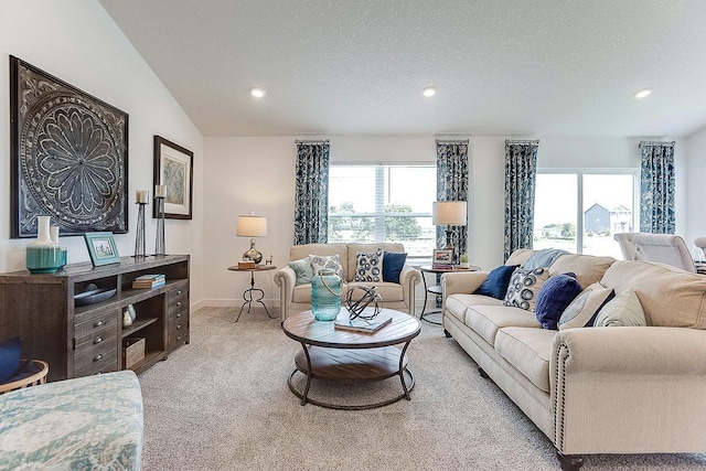 carpeted living room featuring a textured ceiling and vaulted ceiling