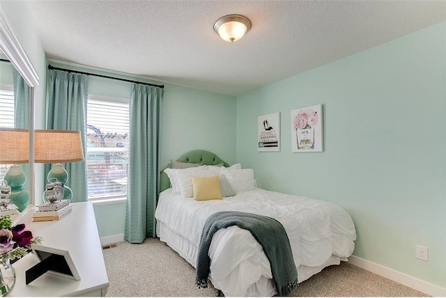 bedroom with light carpet, a textured ceiling, and multiple windows