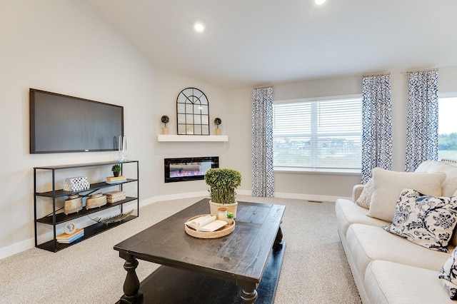 carpeted living room featuring plenty of natural light and lofted ceiling