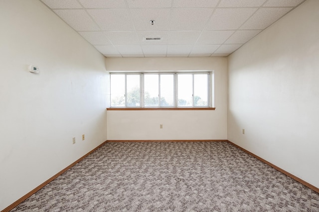 spare room featuring a paneled ceiling and carpet floors