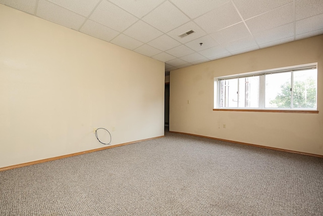 empty room featuring carpet floors and a drop ceiling