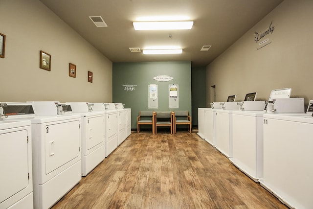 laundry room with light hardwood / wood-style flooring and washing machine and clothes dryer