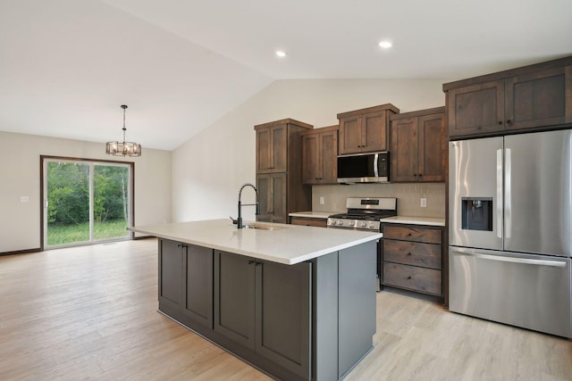 kitchen featuring sink, stainless steel appliances, a notable chandelier, an island with sink, and pendant lighting