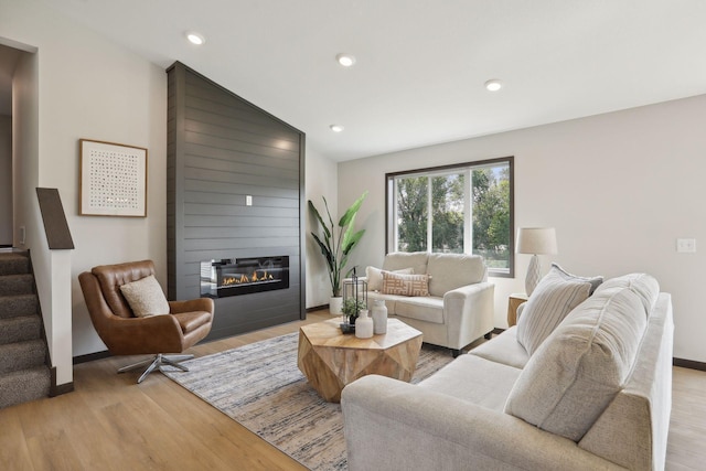 living room featuring a fireplace, light hardwood / wood-style flooring, and lofted ceiling