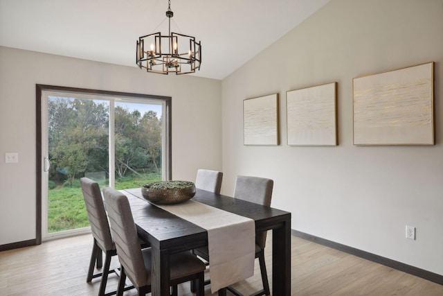 dining area featuring light hardwood / wood-style floors, vaulted ceiling, and a notable chandelier