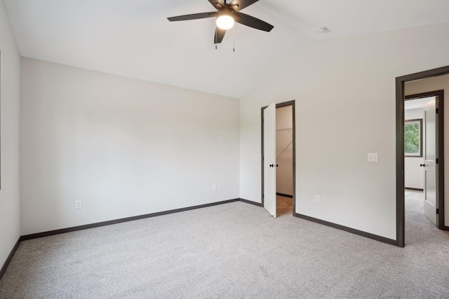 carpeted empty room with ceiling fan and lofted ceiling