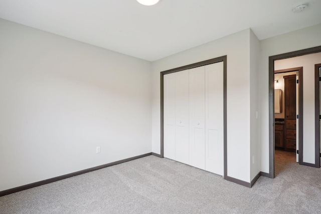 unfurnished bedroom with light carpet and a closet