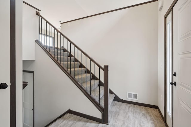 staircase featuring a healthy amount of sunlight and wood-type flooring