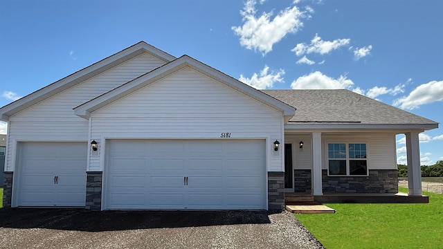 5181 Mustang Ct, Woodbury, MN 55129 - ranch-style home featuring stone siding, an attached garage, asphalt driveway, and covered porch