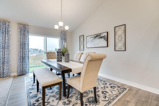 5181 Mustang Ct, Woodbury, MN 55129 - dining area featuring a chandelier, baseboards, light wood-style floors, and vaulted ceiling
