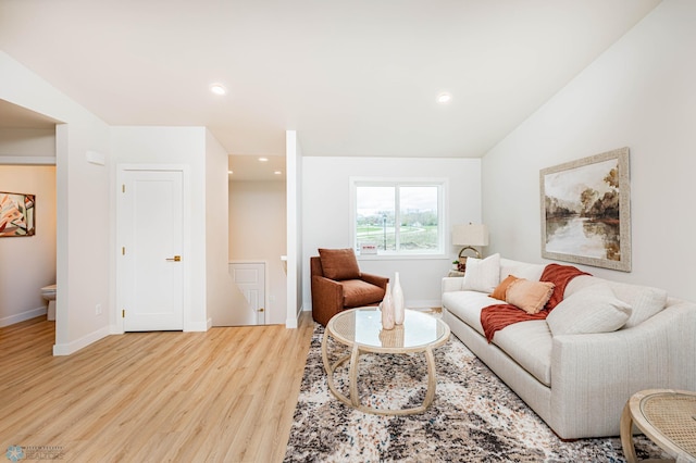 living room featuring light hardwood / wood-style floors and vaulted ceiling