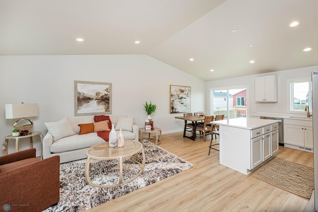 living room with light hardwood / wood-style floors and vaulted ceiling