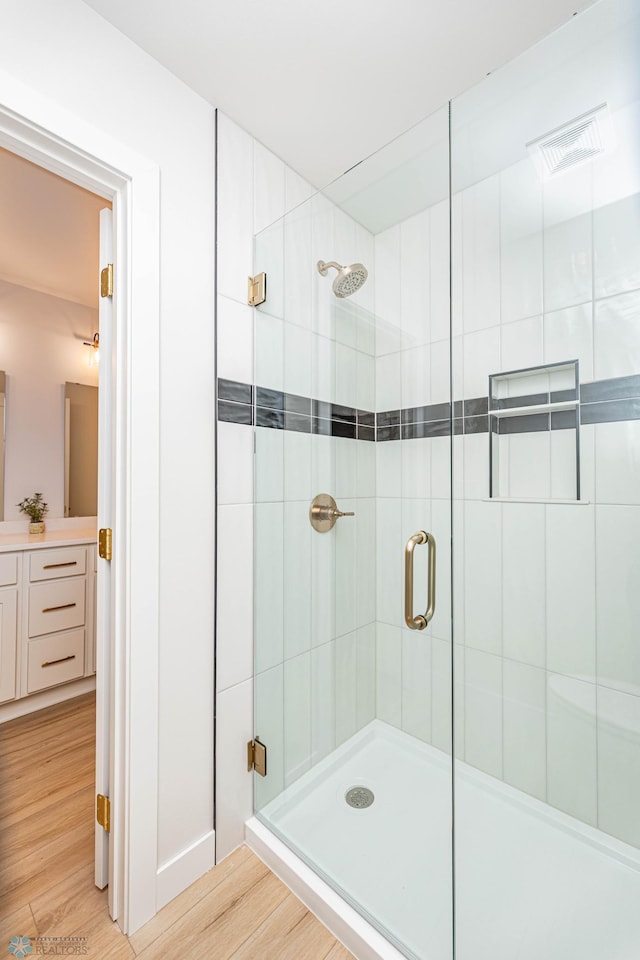 bathroom featuring hardwood / wood-style floors and an enclosed shower