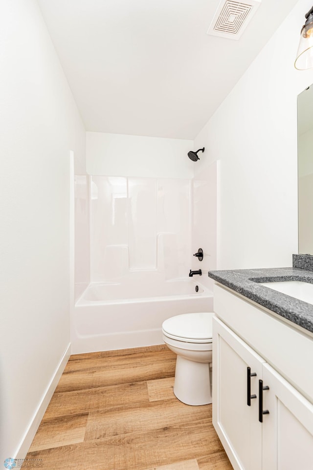 full bathroom with shower / tub combination, vanity, wood-type flooring, and toilet