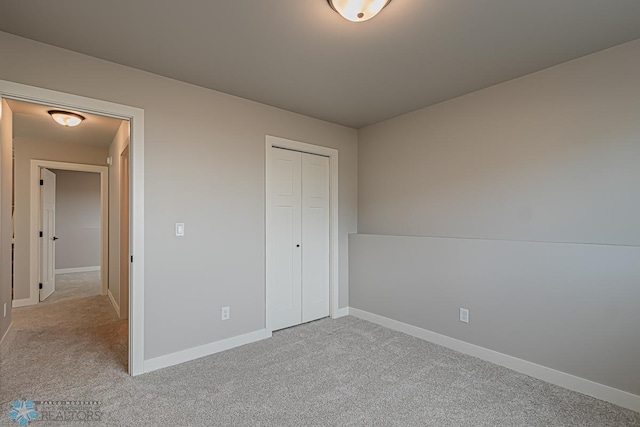 unfurnished bedroom with light carpet and a closet