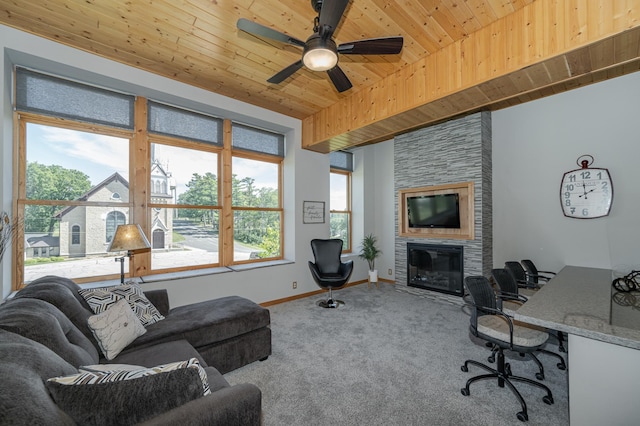 living area featuring baseboards, a fireplace, ceiling fan, wood ceiling, and carpet flooring