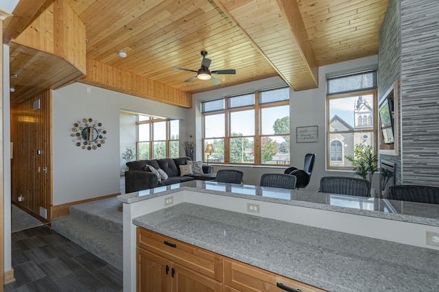 kitchen with a fireplace, wood ceiling, baseboards, and a healthy amount of sunlight