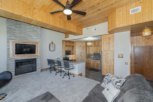 office with wooden ceiling, carpet flooring, visible vents, and a tile fireplace