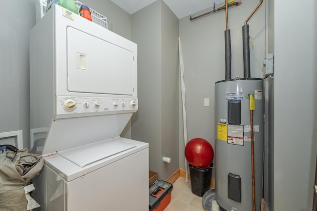 laundry area featuring stacked washer / drying machine, water heater, and laundry area