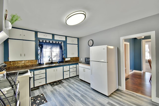 303 Alexandria St NW, Evansville, MN 56326 - kitchen featuring decorative backsplash, white cabinetry, sink, and white refrigerator