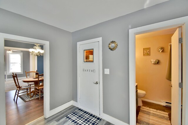 303 Alexandria St NW, Evansville, MN 56326 - foyer with an inviting chandelier, wood-type flooring, and a baseboard heating unit