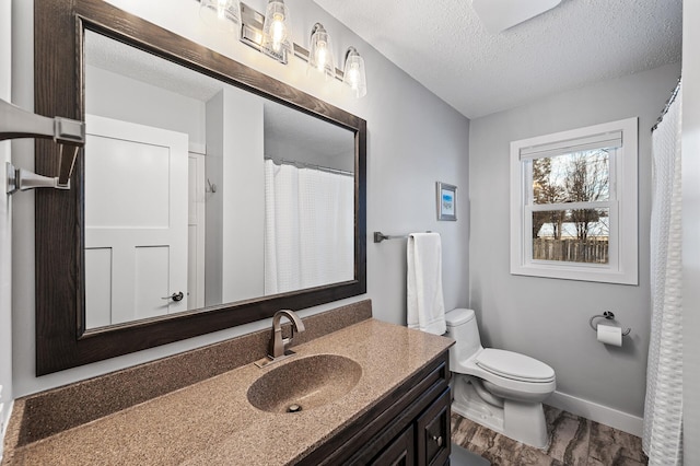 bathroom with vanity, a textured ceiling, and toilet