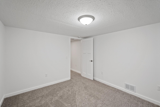 spare room with carpet flooring and a textured ceiling