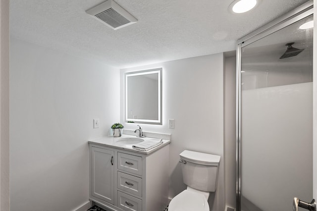 bathroom with vanity, toilet, and a textured ceiling