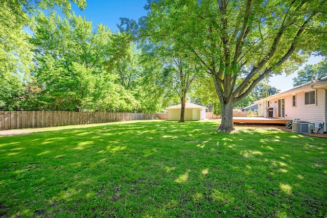 view of yard featuring central AC, a storage shed, and a deck