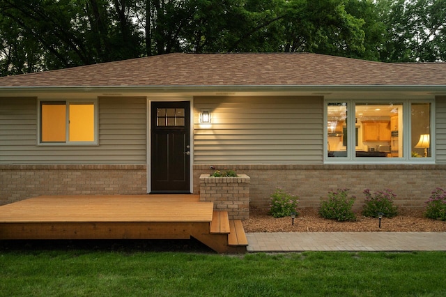 view of front of home with a wooden deck and a front yard