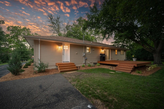 single story home with a yard and a deck