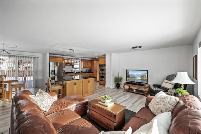 living room featuring light wood-type flooring and a notable chandelier