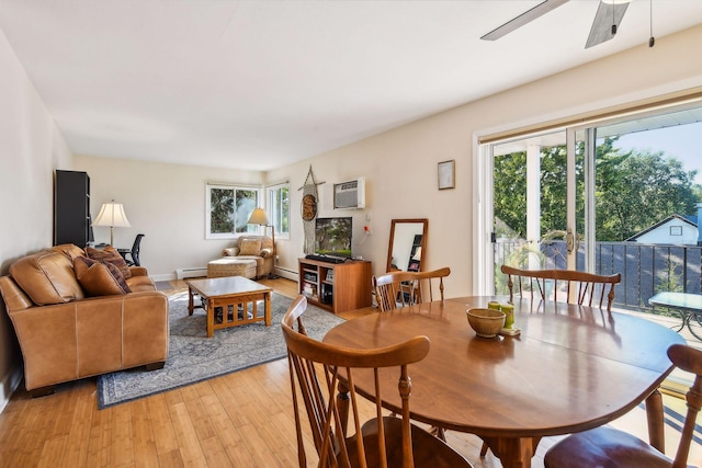 dining area featuring ceiling fan, light hardwood / wood-style flooring, a wall mounted air conditioner, and a baseboard heating unit