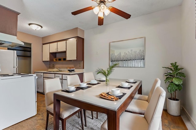 dining area with a textured ceiling, ceiling fan, and sink