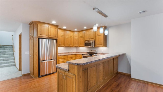 24455 Crocus St NW, Saint Francis, MN 55070 - kitchen featuring a peninsula, baseboards, recessed lighting, light wood-style flooring, and stainless steel appliances