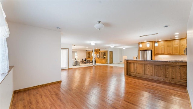 24455 Crocus St NW, Saint Francis, MN 55070 - kitchen with freestanding refrigerator, pendant lighting, baseboards, open floor plan, and light wood finished floors
