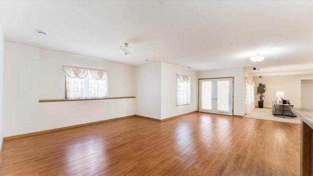 24455 Crocus St NW, Saint Francis, MN 55070 - unfurnished living room featuring baseboards and light wood finished floors