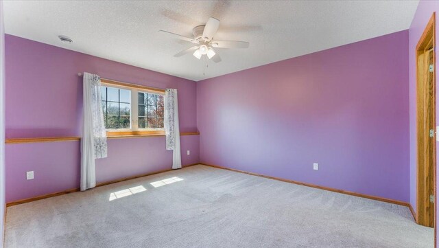 24455 Crocus St NW, Saint Francis, MN 55070 - unfurnished room featuring baseboards, a ceiling fan, carpet, and a textured ceiling