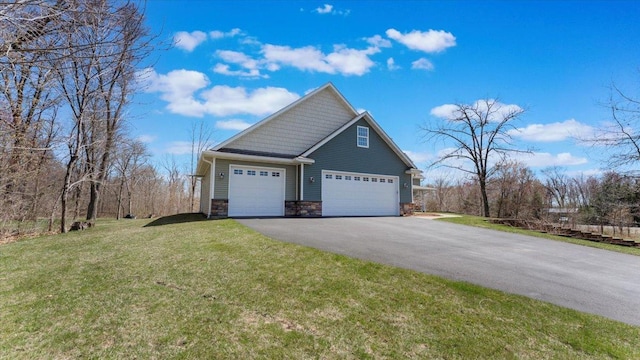 24455 Crocus St NW, Saint Francis, MN 55070 - view of home's exterior with an attached garage, aphalt driveway, a yard, and stone siding