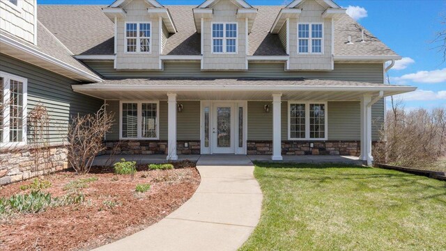 24455 Crocus St NW, Saint Francis, MN 55070 - craftsman-style home featuring a shingled roof, a front yard, a porch, and stone siding