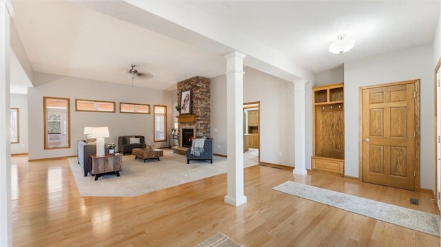 24455 Crocus St NW, Saint Francis, MN 55070 - living area with ornate columns, light wood-style flooring, baseboards, and a stone fireplace