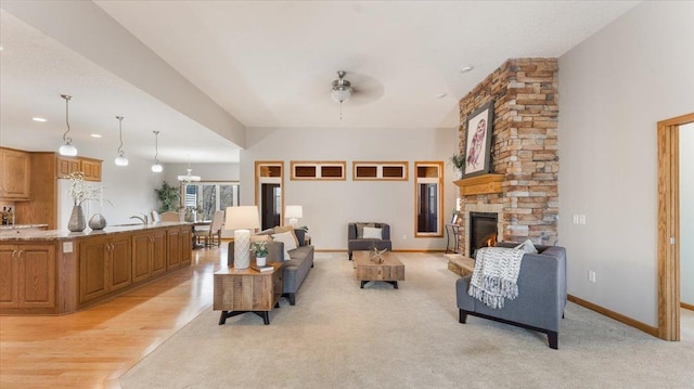 24455 Crocus St NW, Saint Francis, MN 55070 - living area with baseboards, a stone fireplace, ceiling fan with notable chandelier, and light wood-style floors