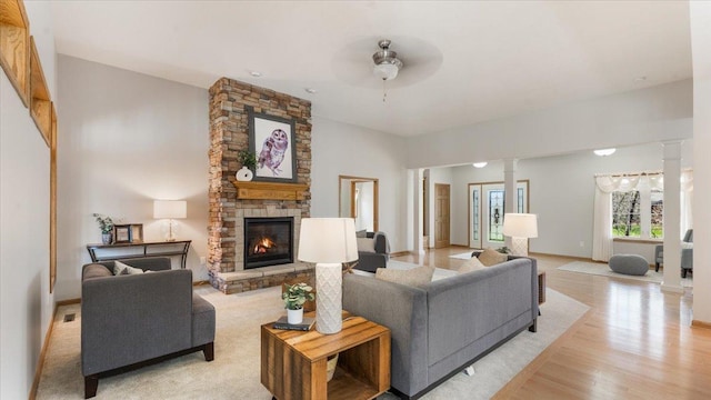 24455 Crocus St NW, Saint Francis, MN 55070 - living room featuring ornate columns, a ceiling fan, a fireplace, and light wood-type flooring