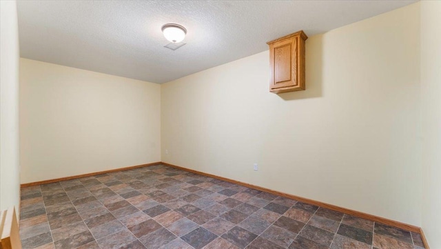 24455 Crocus St NW, Saint Francis, MN 55070 - unfurnished room with a textured ceiling, baseboards, and stone finish floor