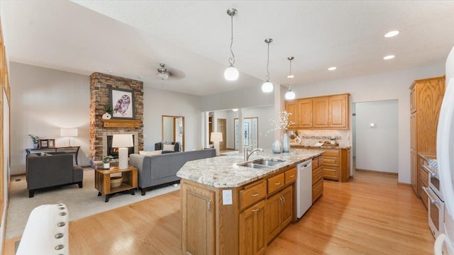 24455 Crocus St NW, Saint Francis, MN 55070 - kitchen featuring a stone fireplace, white dishwasher, a center island with sink, a sink, and light wood finished floors