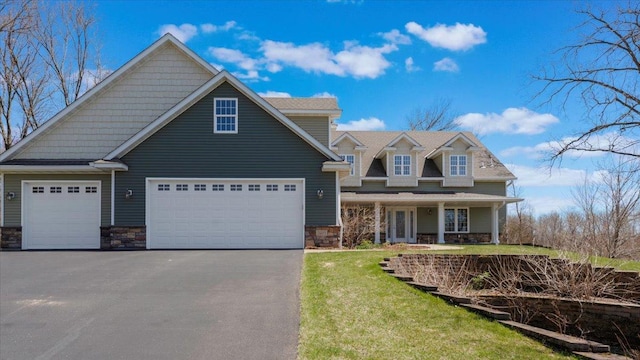 24455 Crocus St NW, Saint Francis, MN 55070 - view of front of property with a garage, a front lawn, aphalt driveway, covered porch, and stone siding