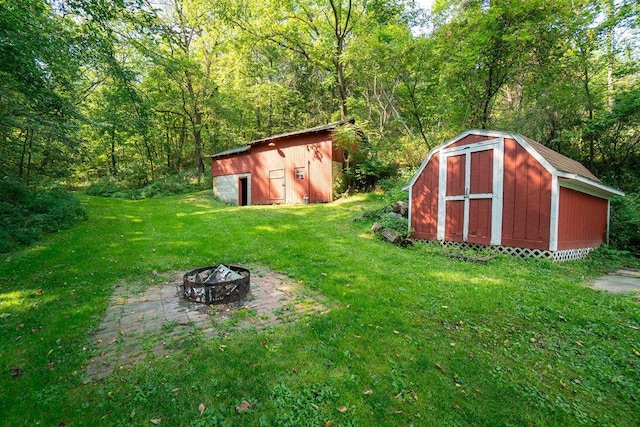 view of outdoor structure with a fire pit and a lawn