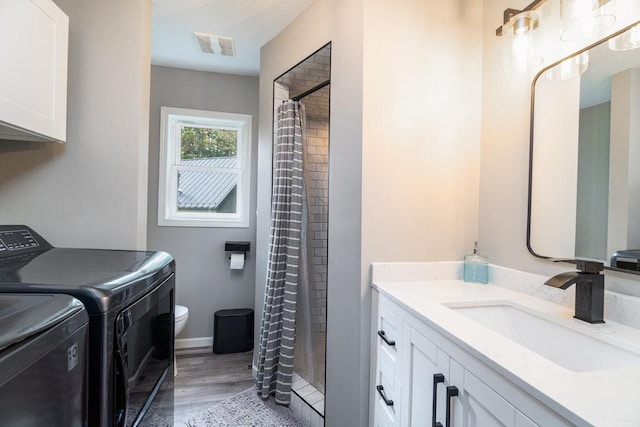 clothes washing area featuring light wood-type flooring, separate washer and dryer, and sink